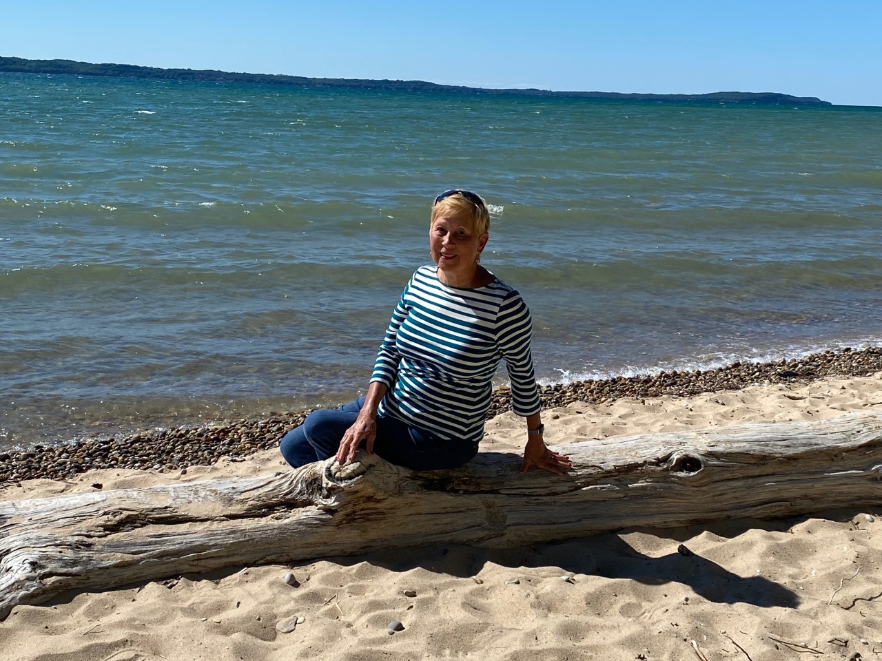 Woman on Driftwood at Grand Traverse Bay