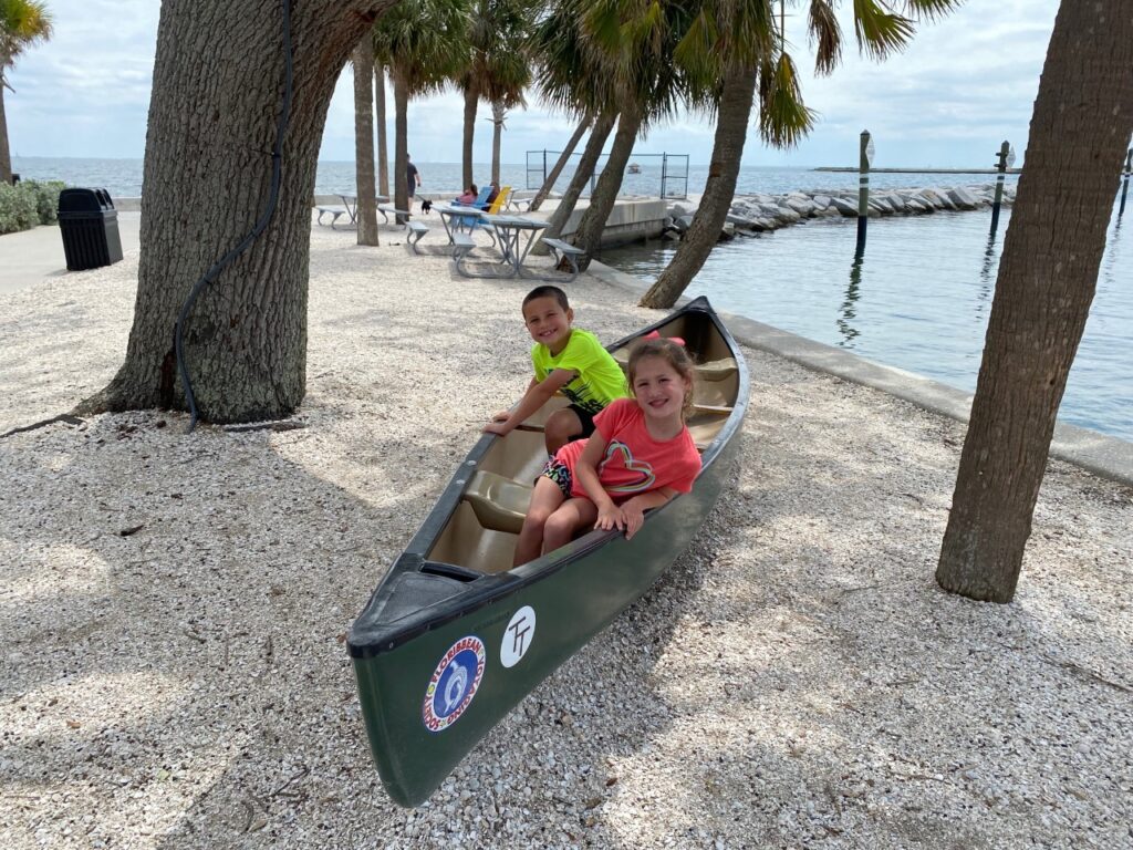 Keaton and Kaia pose in an "Adventure Canoe"