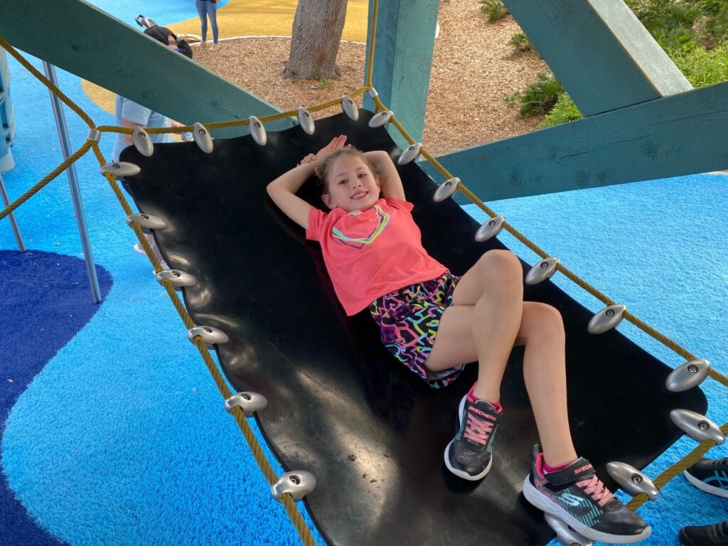 Kaia relaxes in the hammock under the slide.