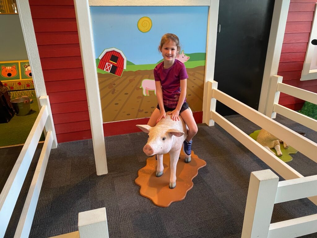 Kaia rides a pig.