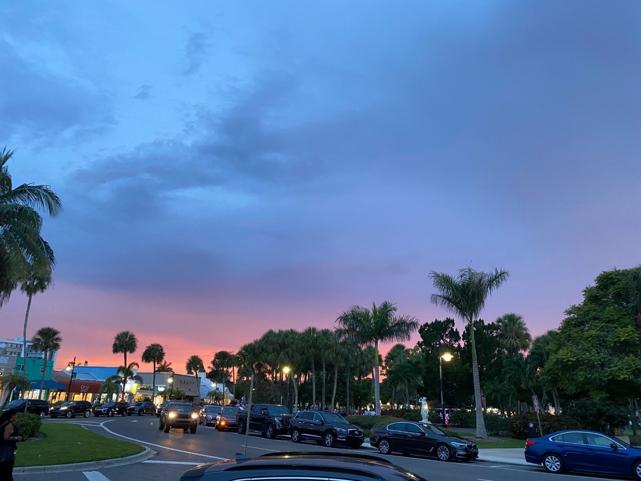 St. Armands Circle after a rain shower with a pink-orange sky at sunset.