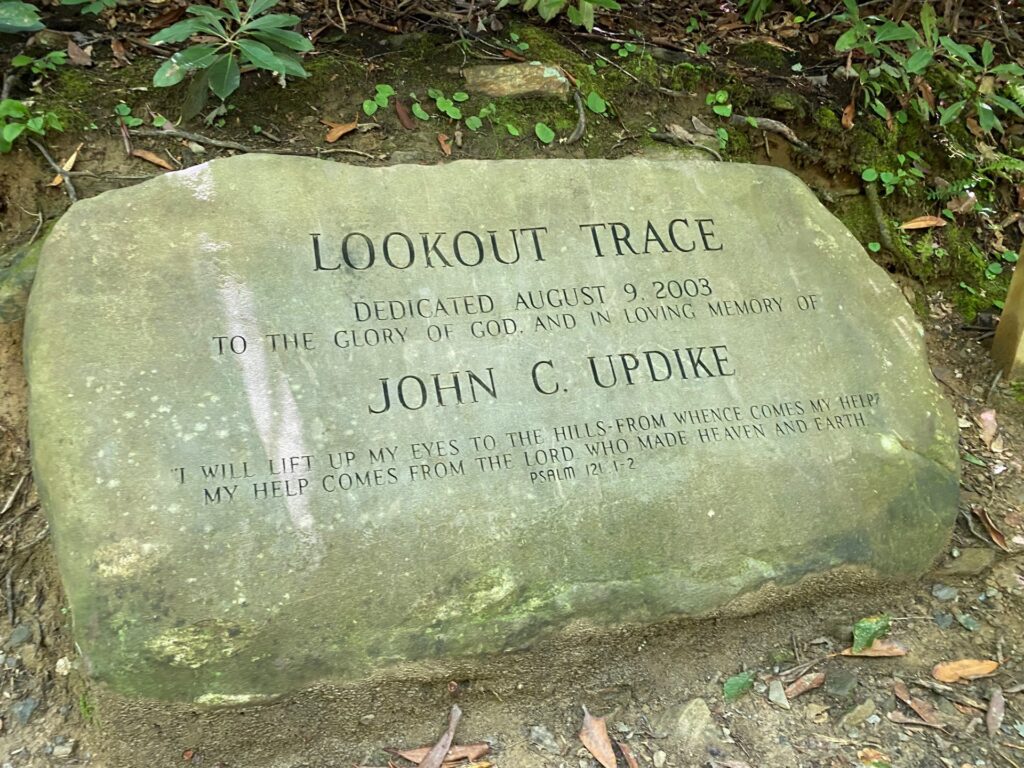 The LOOKOUT TRACE dedication stone marks the beginning of Lookout Trail and a parking lot.