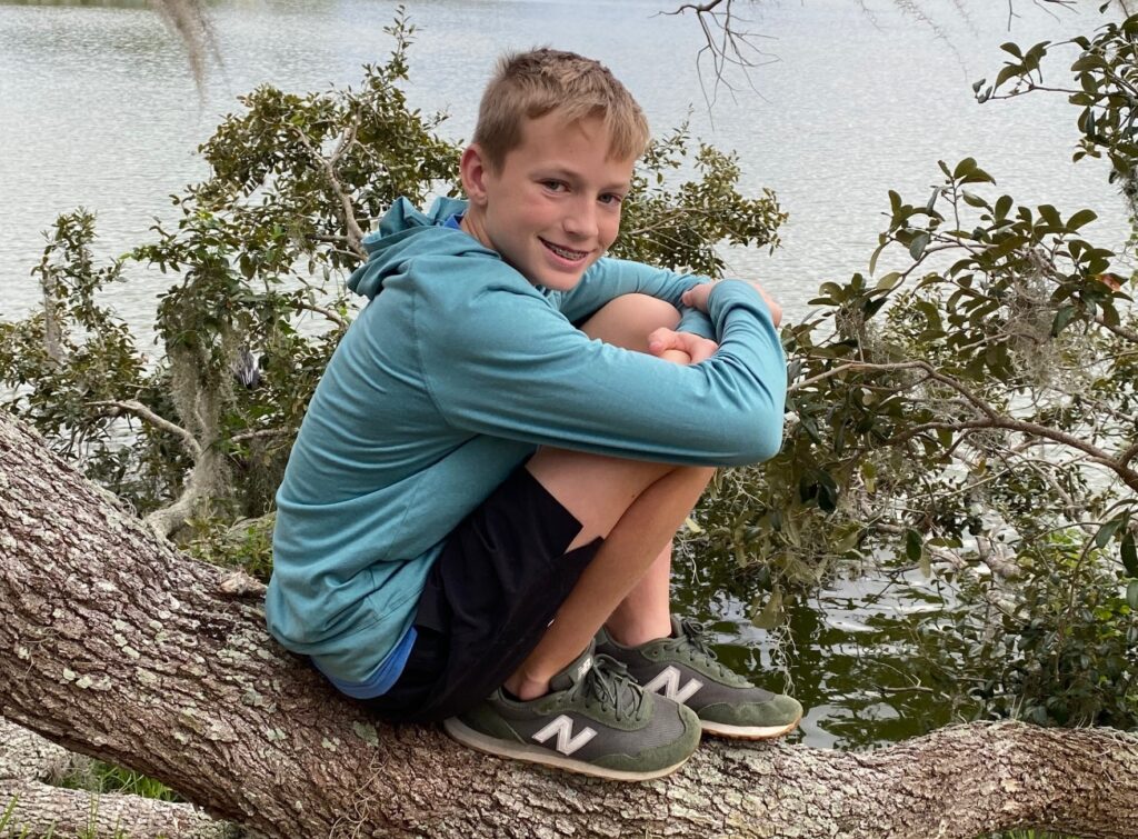 Louis poses on the tree branch over the water.