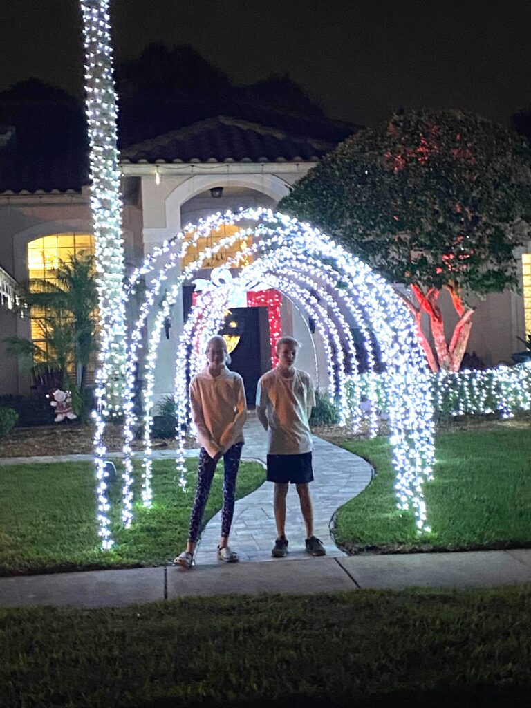 Posing under the lighted walkway of a house in the neighborhood.