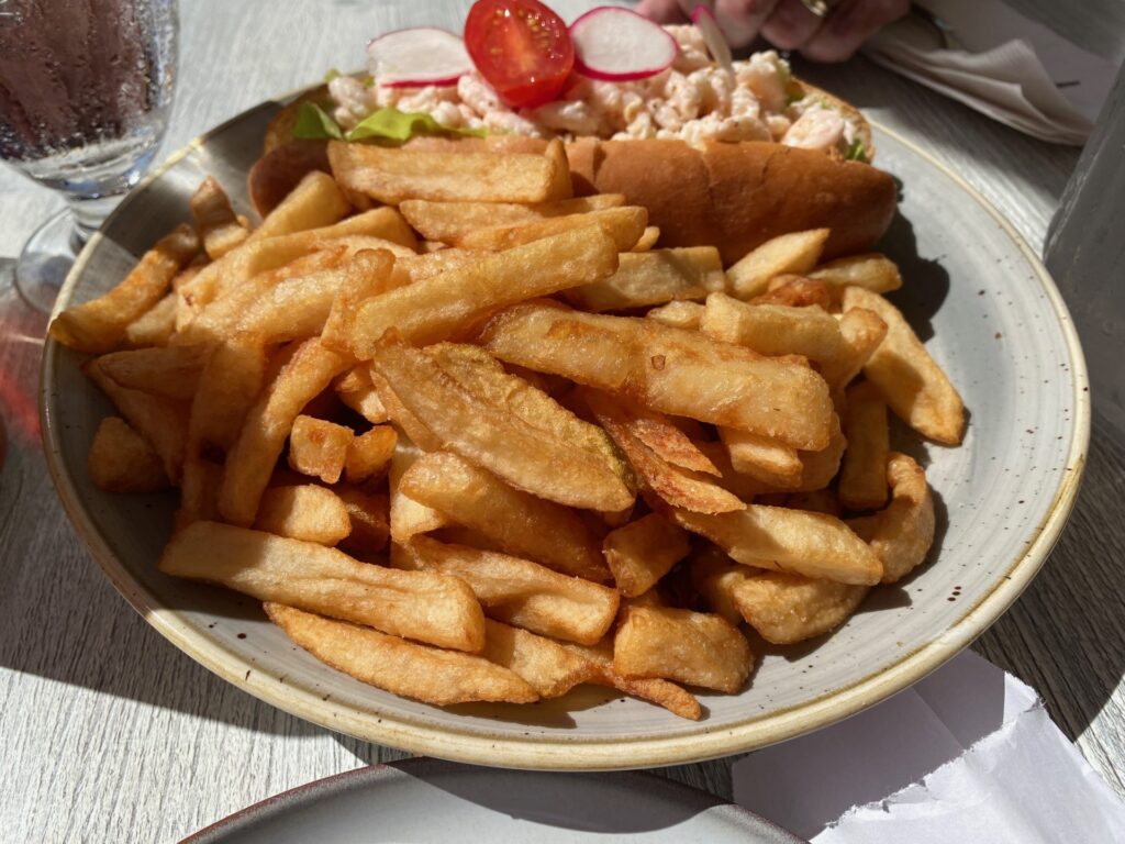 The delicious Shrimp Rolll with fries and fresh salad.